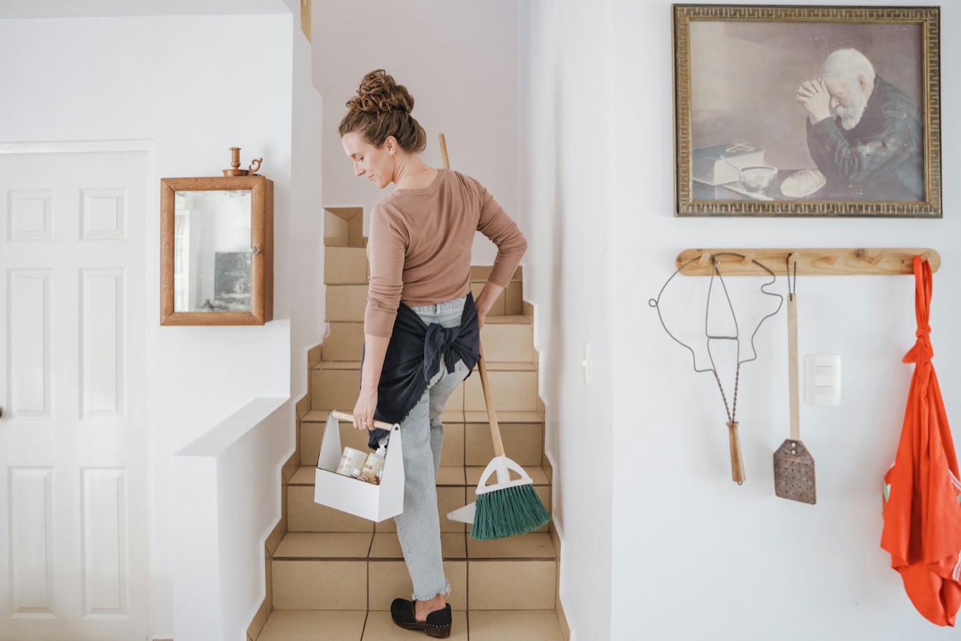 Cleaner carrying supplies up the stairs