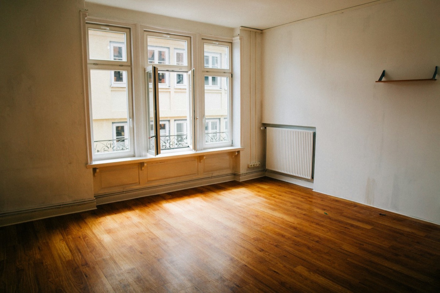 Empty, freshly cleaned room with wood floors and big windows